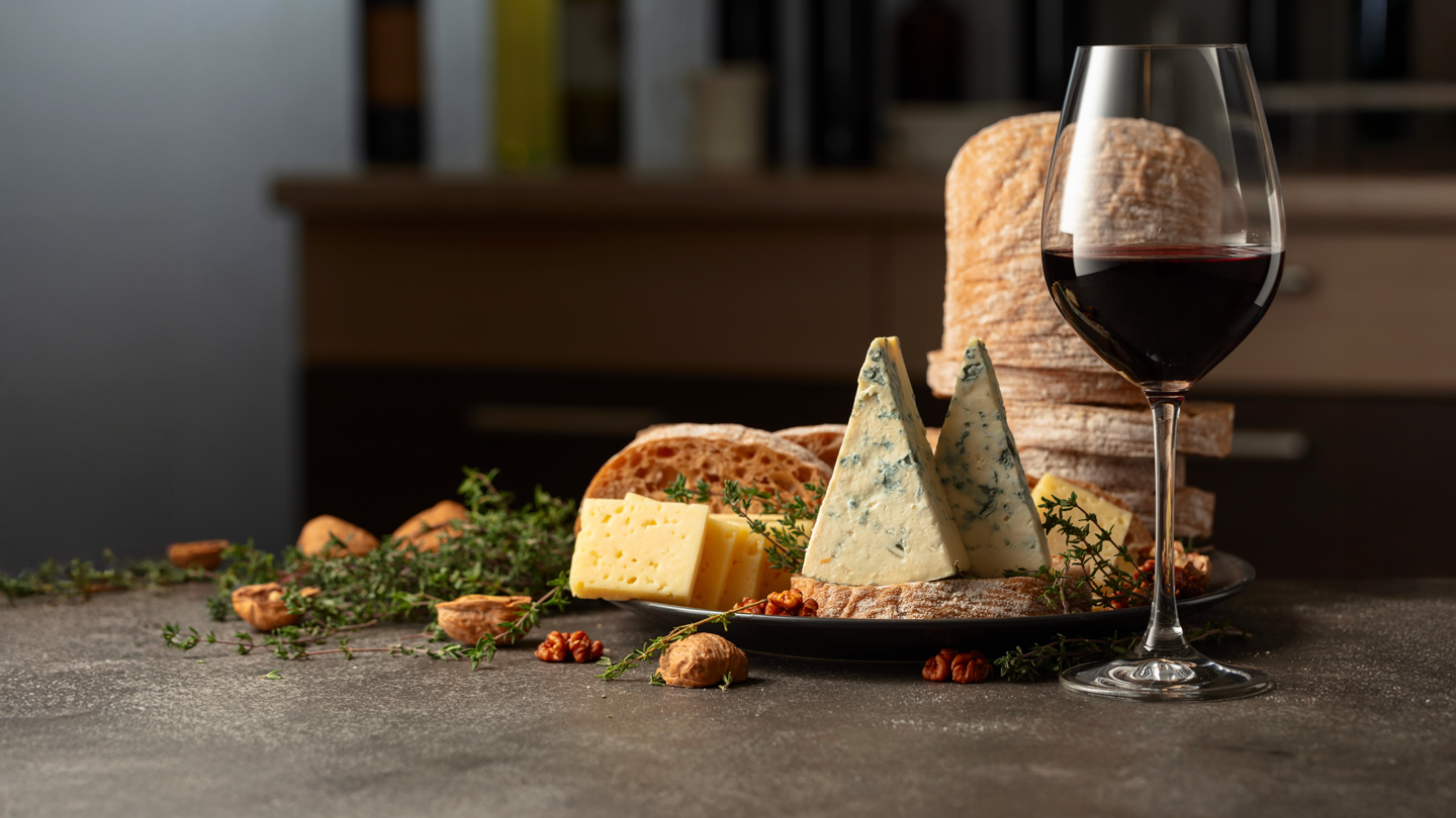 Glass of red wine with blue cheese, walnuts, and rustic bread